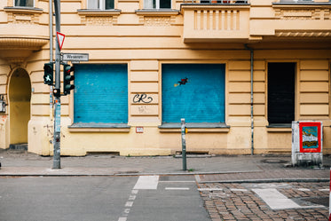 yellow city building with blue blinds