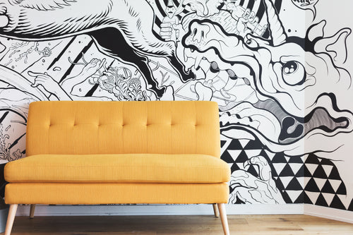 yellow couch by black and white mural