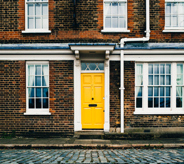 yellow door on brick home