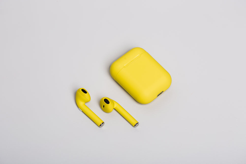 yellow earbuds on white