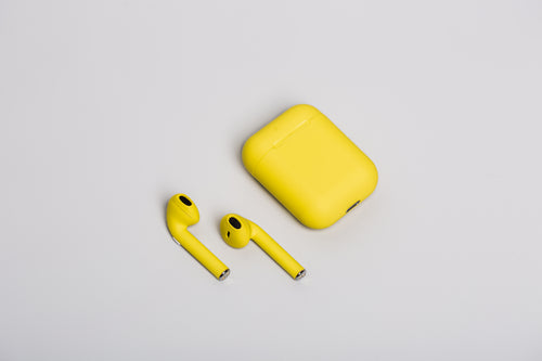 yellow earbuds on white