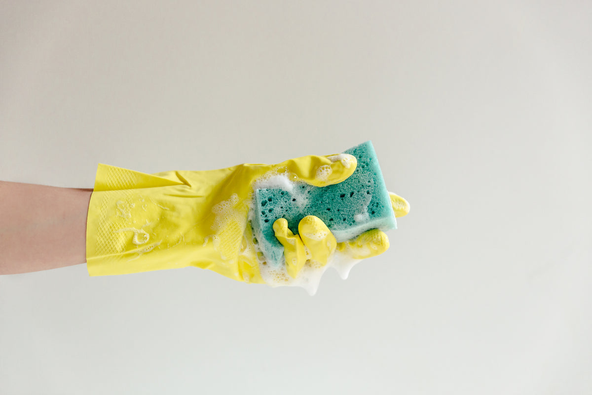 yellow glove and blue sudsy sponge