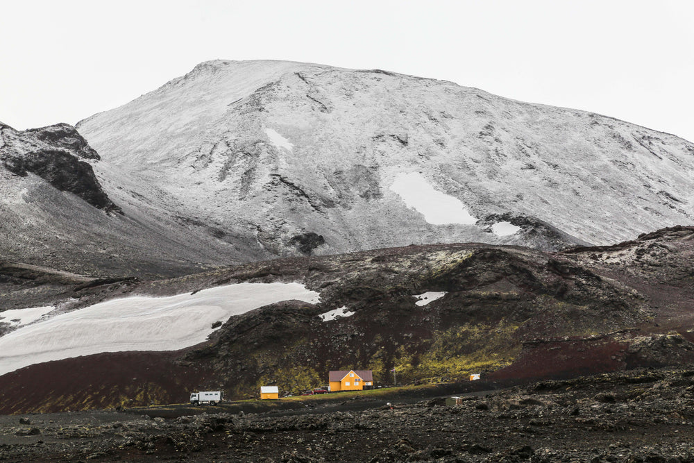 yellow house under the grey mountain