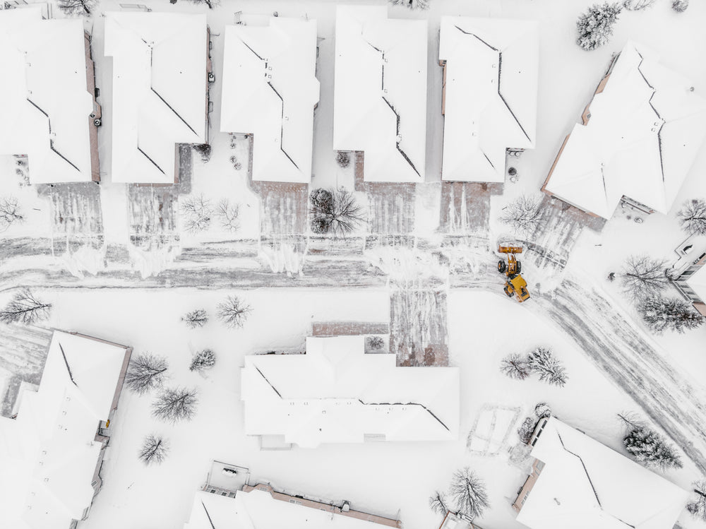 yellow snow plow clearing suburban streets