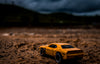 yellow toy car in dramatic desert landscape