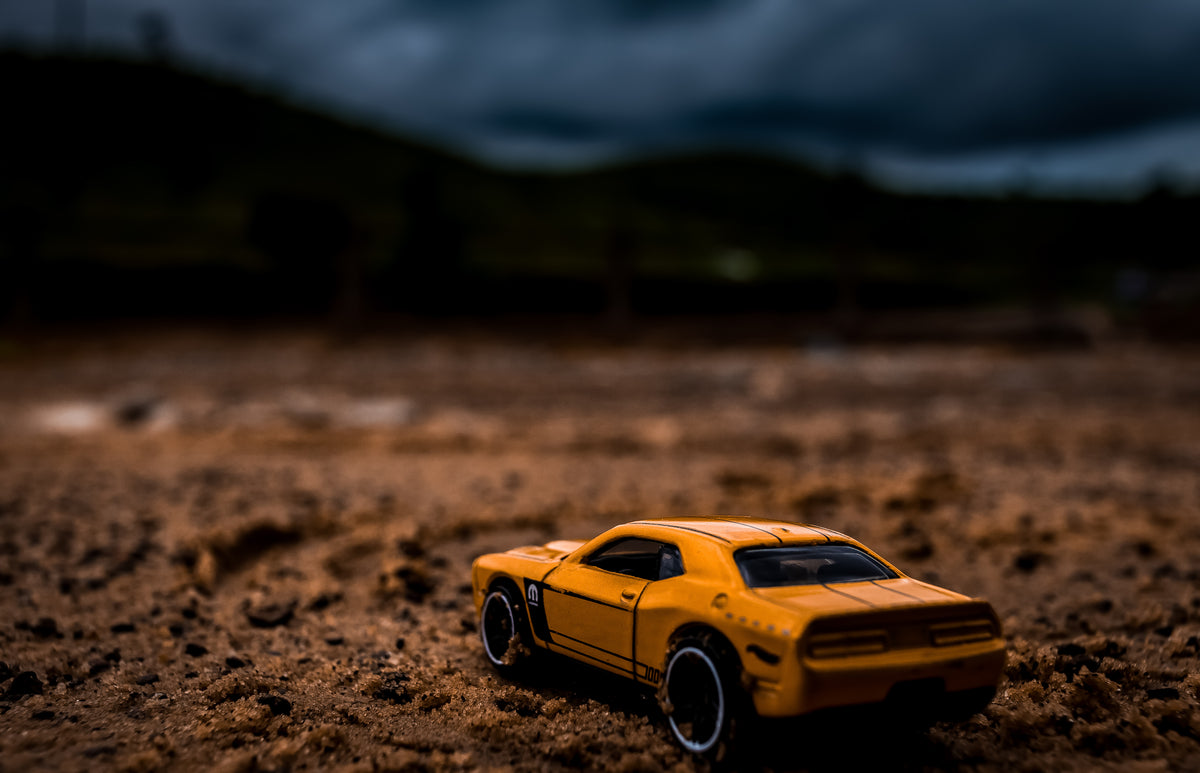 yellow toy car in dramatic desert landscape
