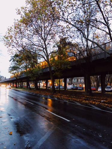 yellow train on track and rainy roads