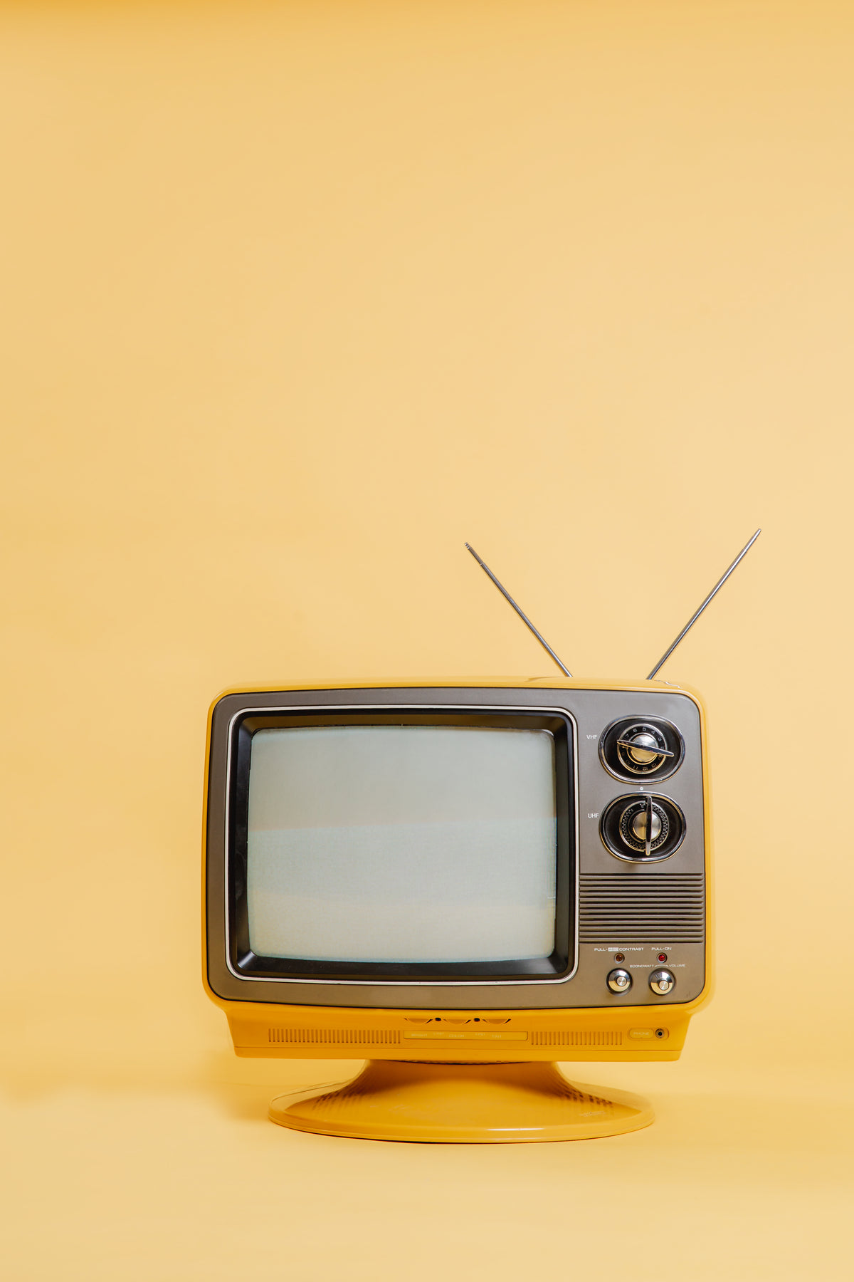 黄色电视机在单色无缝背景