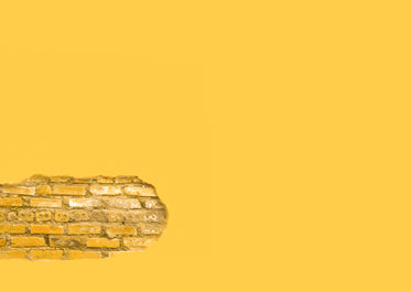 yellow wall with a section of exposed brick