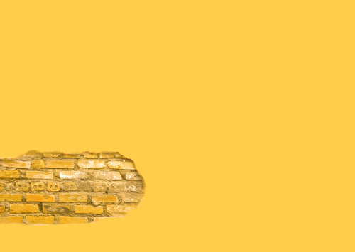 yellow wall with a section of exposed brick
