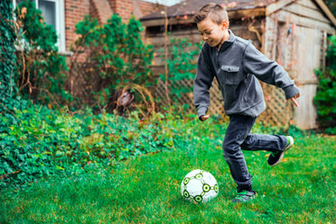 young boy kicking ball
