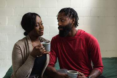 young couple sit together with coffee