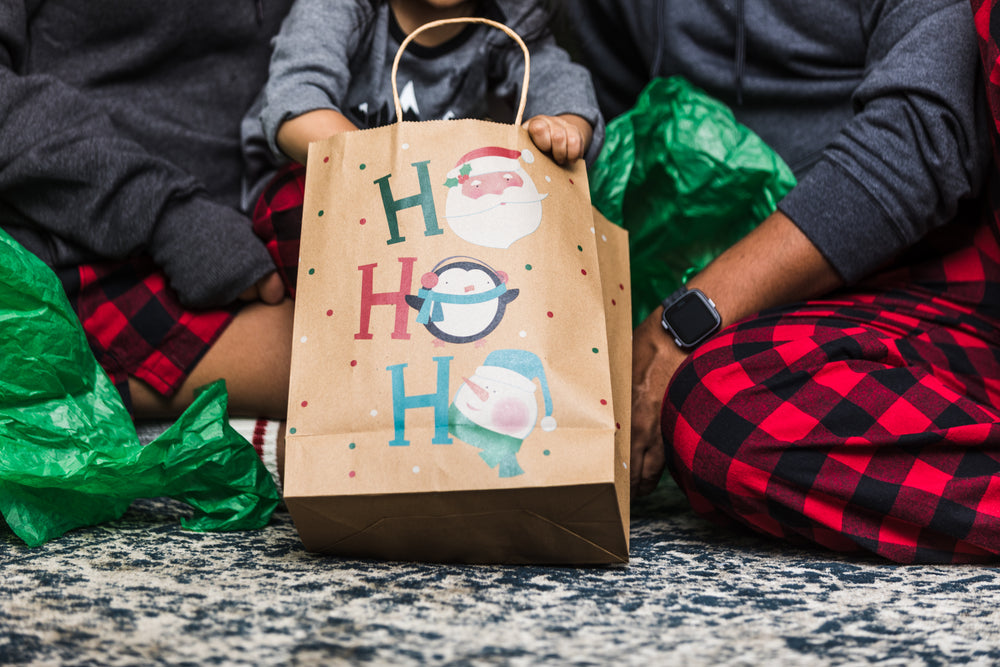 jovem família abre presentes de natal juntos