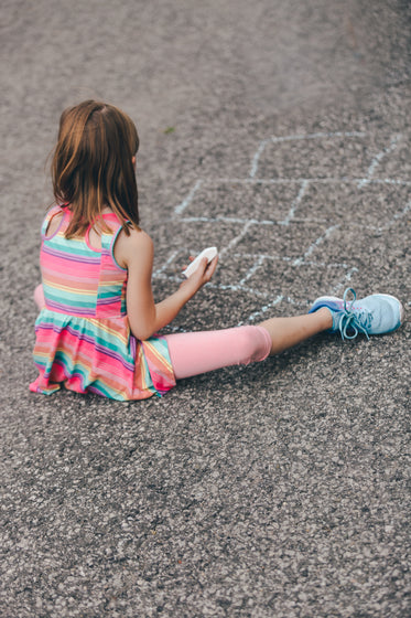 young girl drawing hopscotch