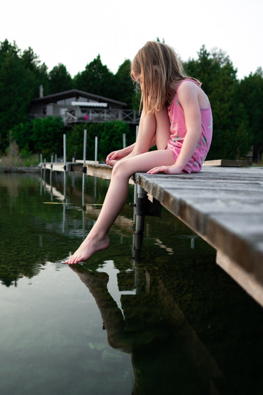 young girl on dock foot in water