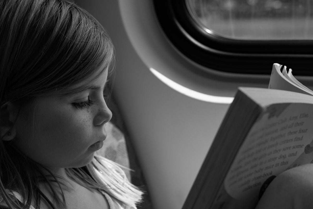young girl reading on train