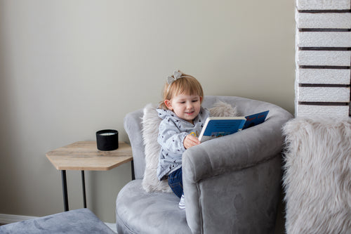 young girl reads in comfy chair