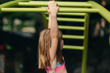 young girl swinging on bars