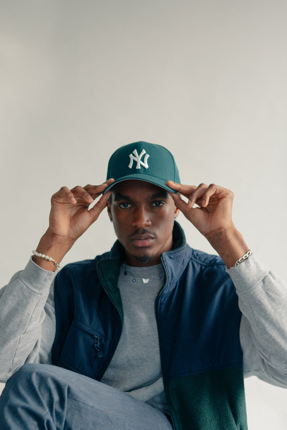 young man adjusts his baseball cap