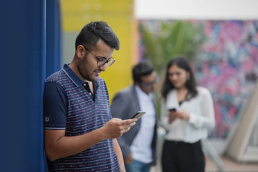 young man against wall on his phone