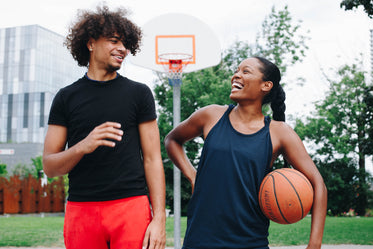 young man and woman share laugh on the court