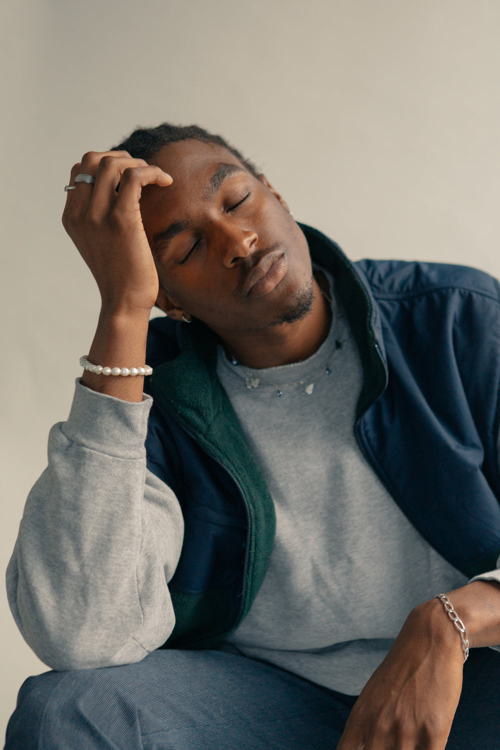 young man holds head with closed eyes