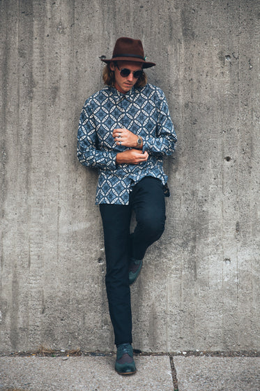 young man leans on wall