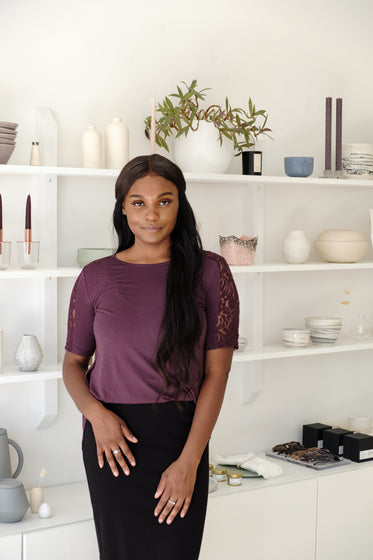 young model stands in front of shelf