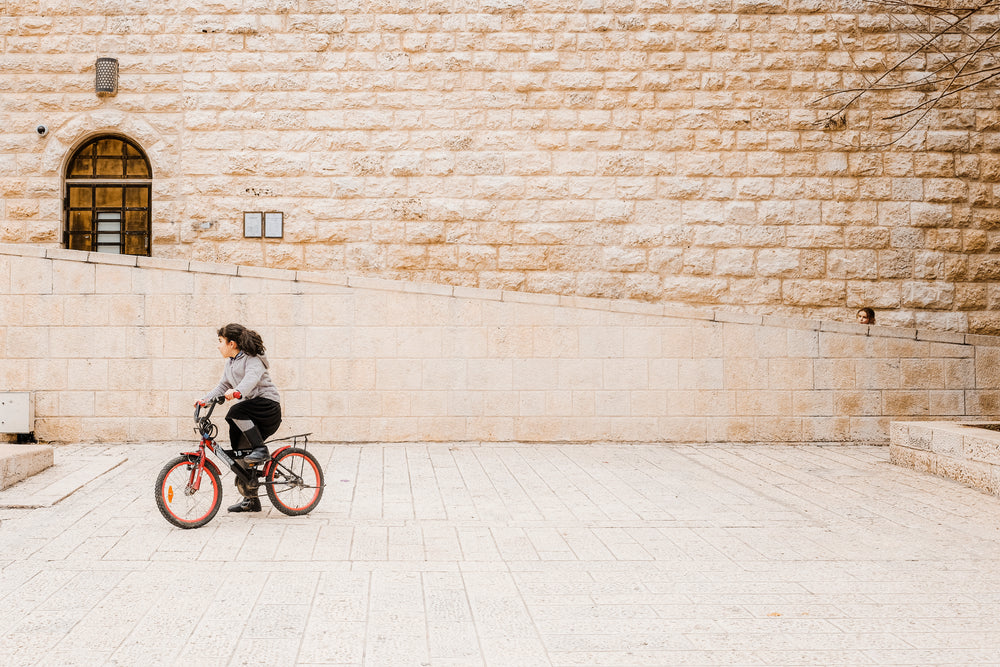 young person riding a bike on stone surface