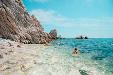 young person swims in crystal clear ocean