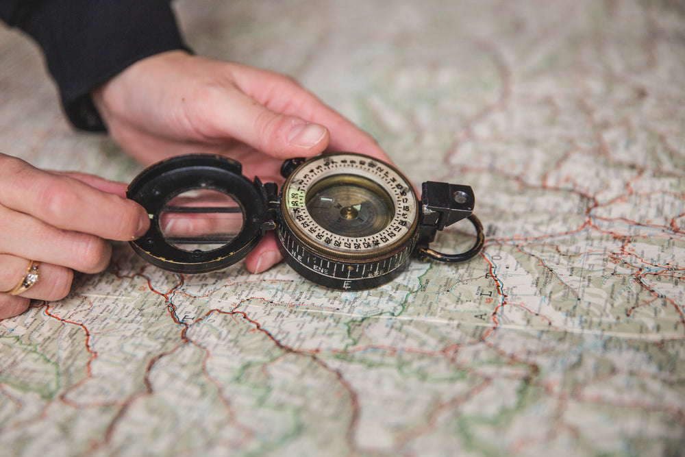 young woman holding compass over map