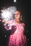 young woman holds out sparkler