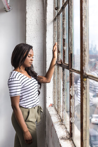 young woman leaned into window frame