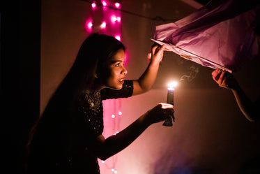 young woman places candle inside lantern