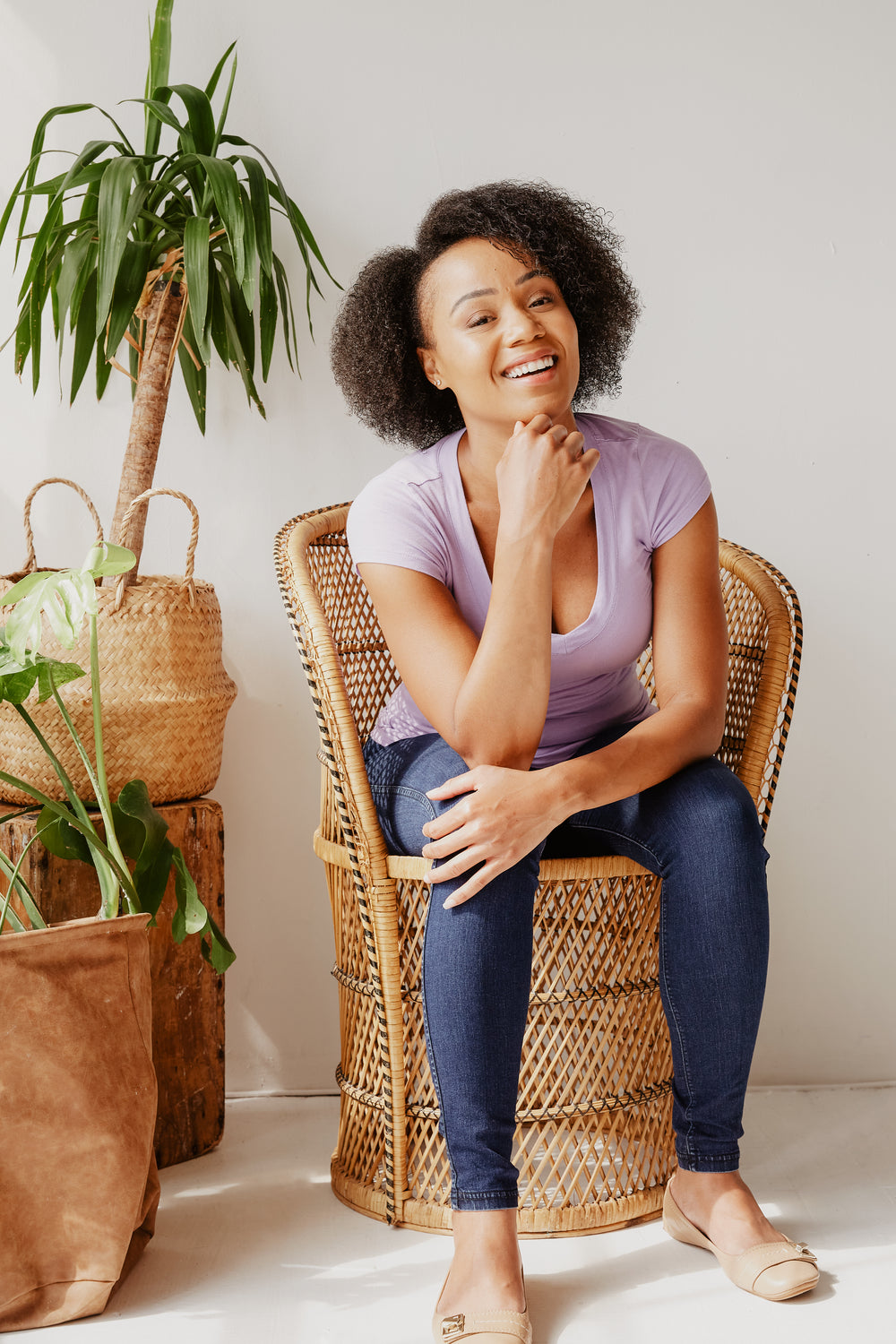 young woman posing in wicker chair