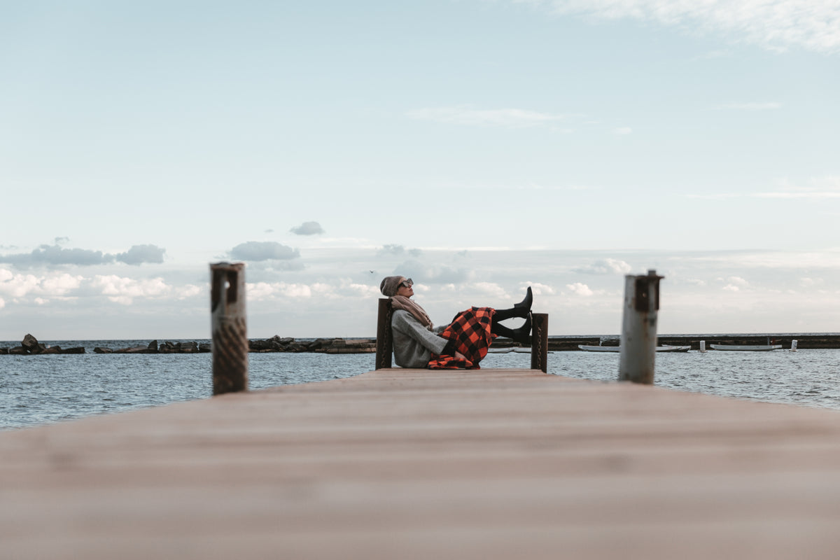 young woman sitting at the edge of a dock