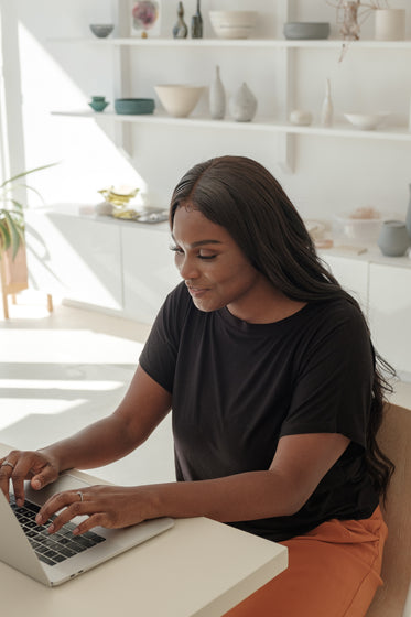 young woman smiles as she checks on her online store