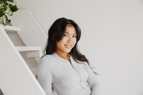 young woman smiles while posing on steps