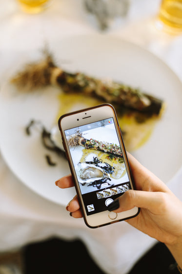 young woman snaps photo of food