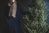 young woman standing with christmas tree