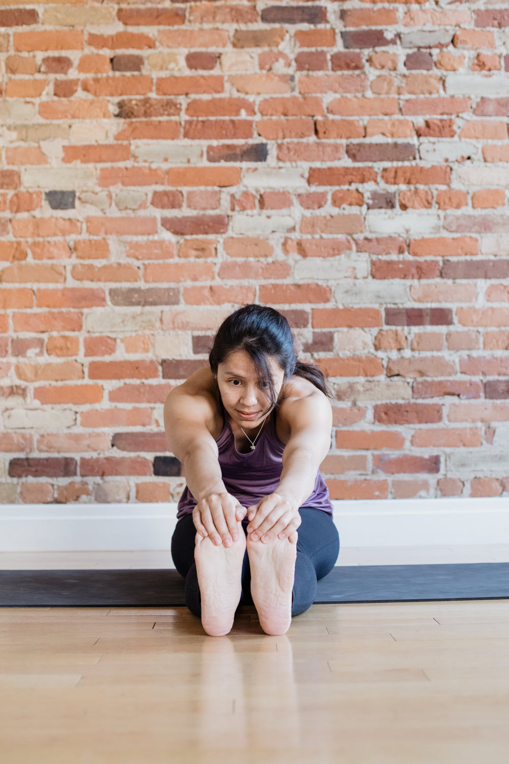 young woman touching toes in yoga