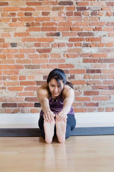 young woman touching toes in yoga