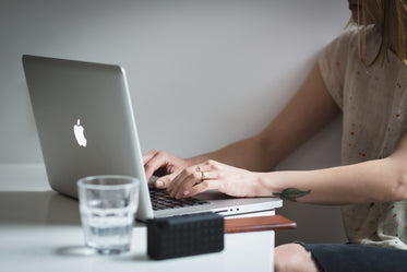 young woman typing macbook