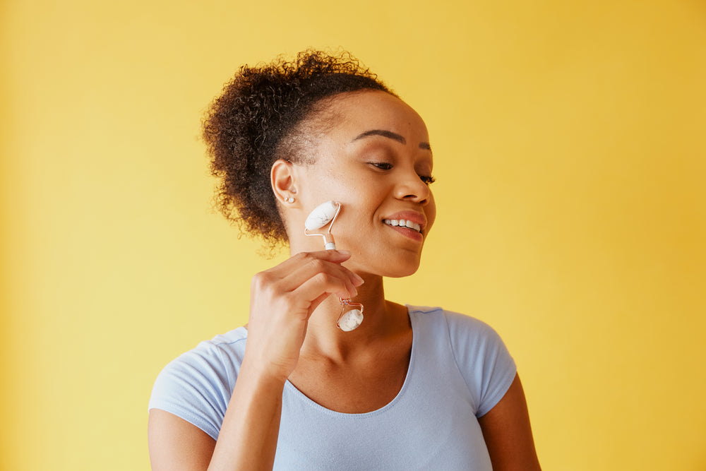 young woman using facial roller