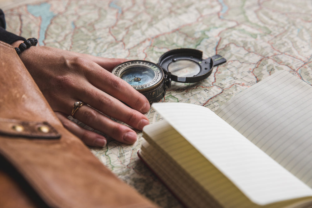 young woman with compass and notebook