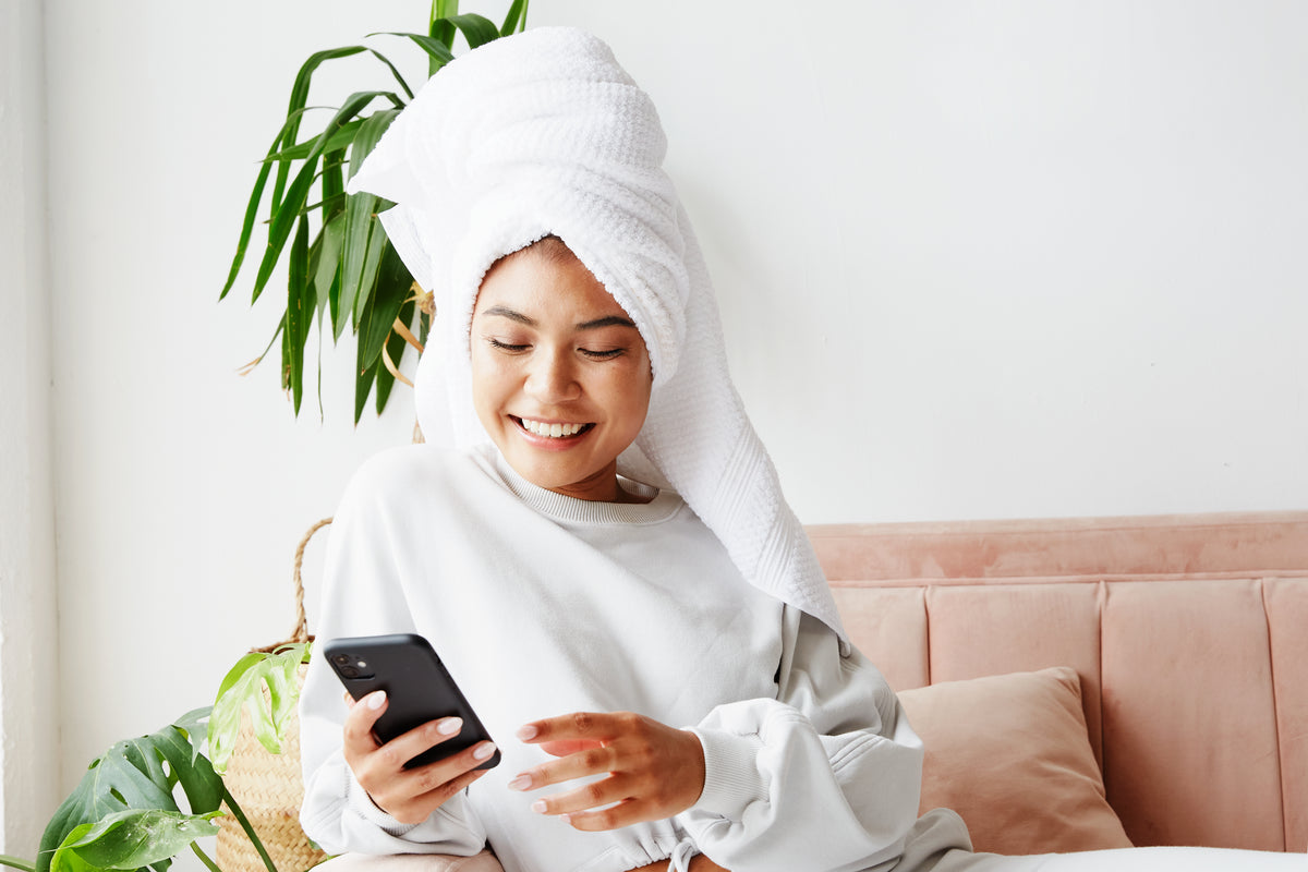 young woman with hair wrapped while on her phone