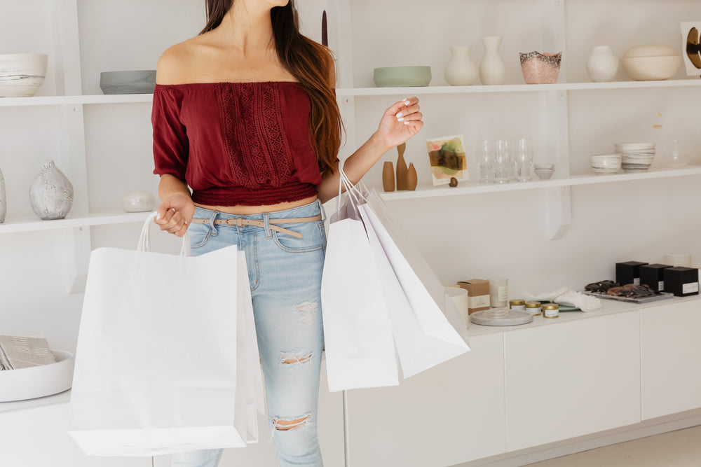 young woman with white shopping bags